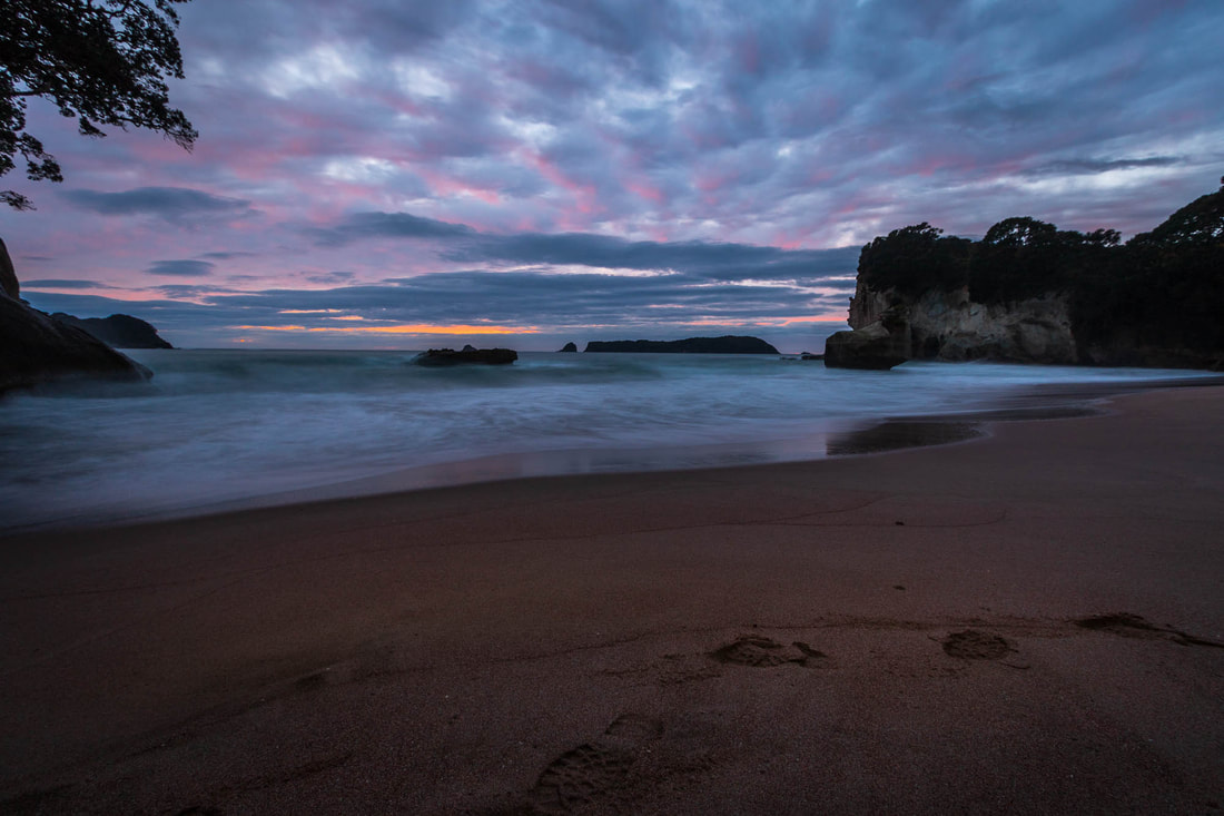 Long-exposure landscape image before sunrise at Cathedral Cove, New Zealand